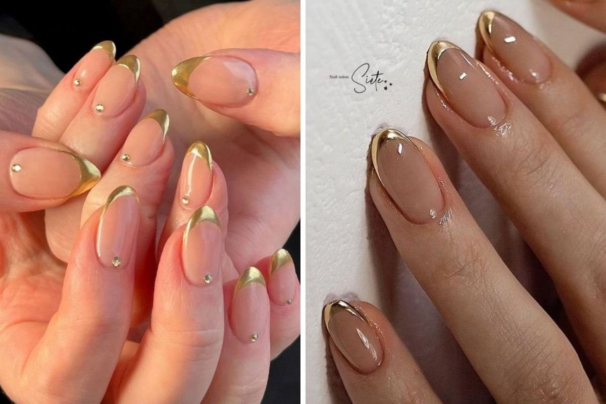 Unhas decoradas com esmalte nude, pontas douradas e pequenos detalhes brilhantes.