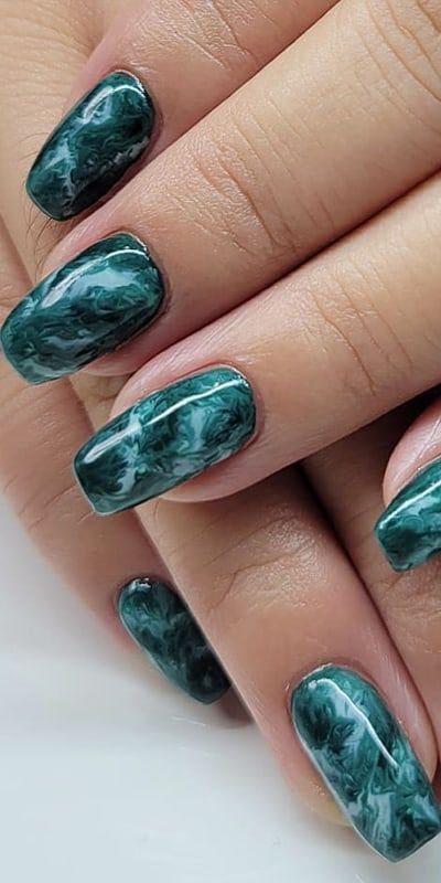 3cdee9bdaf18af1c63a6ef44356220bf Unhas decoradas com esmalte verde marmorizado sobre fundo claro.