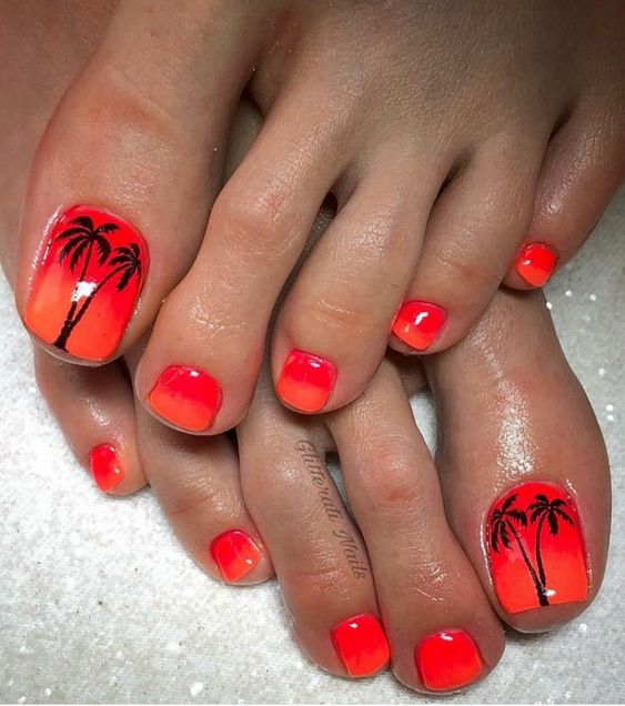 Unhas dos pés pintadas de laranja com desenhos de palmeiras pretas nos dedões.