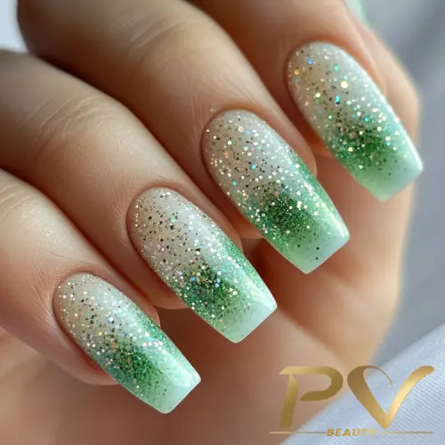 Unhas decoradas com esmalte degradê verde e glitter brilhante.