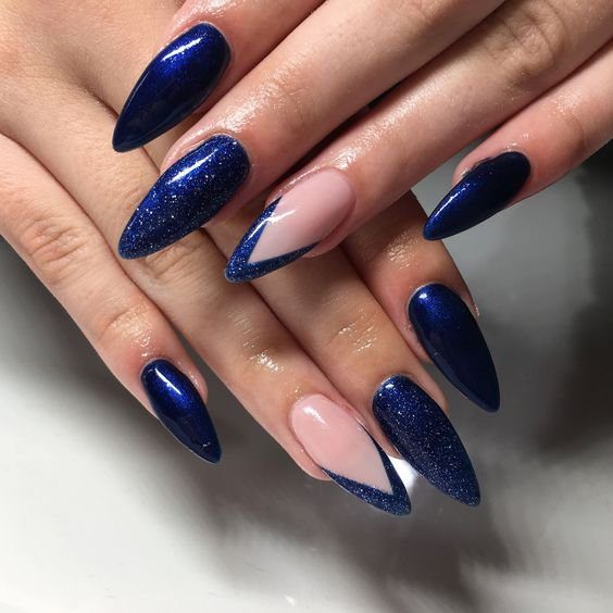 azuis-com-pouco-brilho-tambem-criam-unhas-elegantes-e-mais-basicas-para-o-carnaval Unhas longas e pontiagudas com esmalte azul metálico e detalhes em nude e azul.