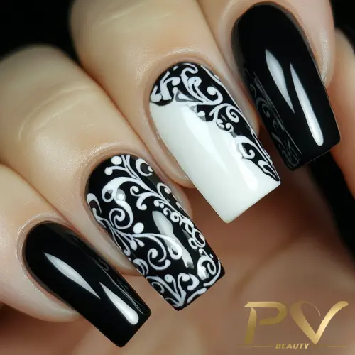 Unhas decoradas em preto e branco com desenho floral detalhado e acabamento brilhante.