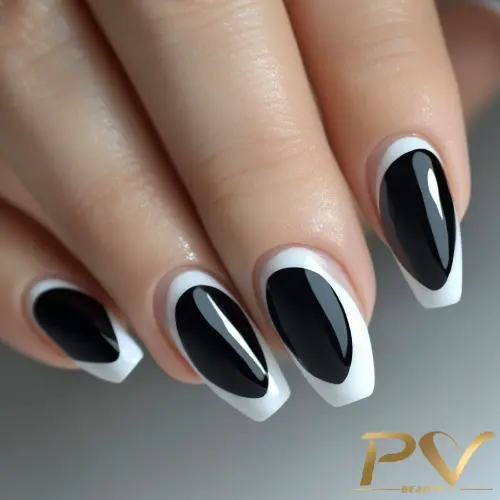 Unhas decoradas com esmalte preto e branco em um design geométrico elegante.