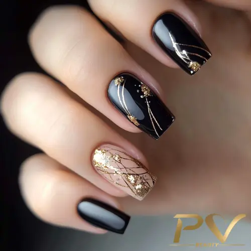 Unhas decoradas com esmalte preto e dourado, exibindo detalhes metálicos e desenhos elegantes.