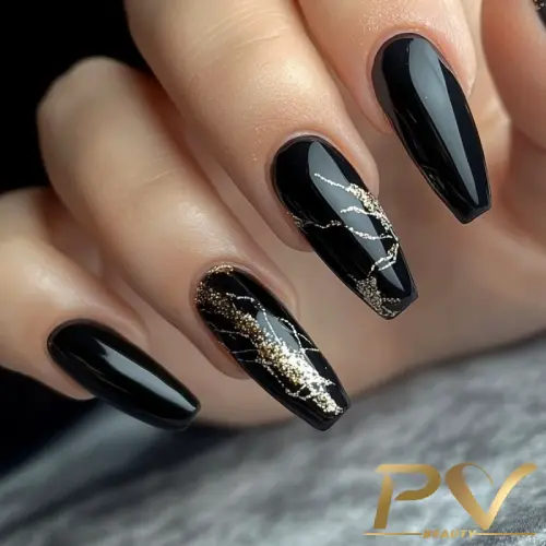 Unhas compridas com esmalte preto e detalhes dourados em design elegante.