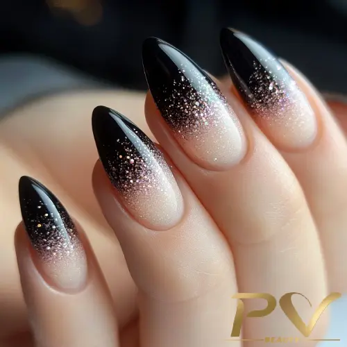 Unhas com esmalte degradê preto e nude, decoradas com glitter.