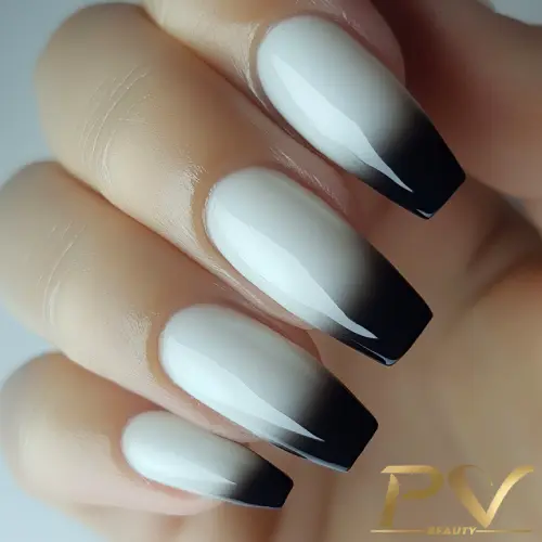 Unhas com esmalte em degradê do branco ao preto, acabamento brilhante.