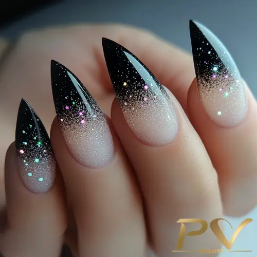 Unhas pontiagudas com esmalte preto e glitter colorido, criando um efeito degradê elegante.