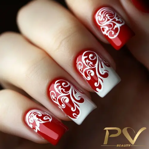 Unhas decoradas com esmalte vermelho e branco, exibindo desenhos intrincados e detalhados.