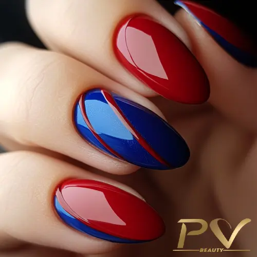 Unhas decoradas com esmalte vermelho e azul, em design geométrico e acabamento brilhante.