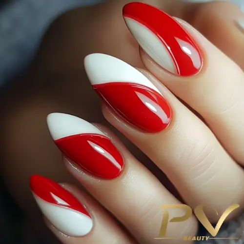 Unhas decoradas com esmalte vermelho e branco em um design geométrico.