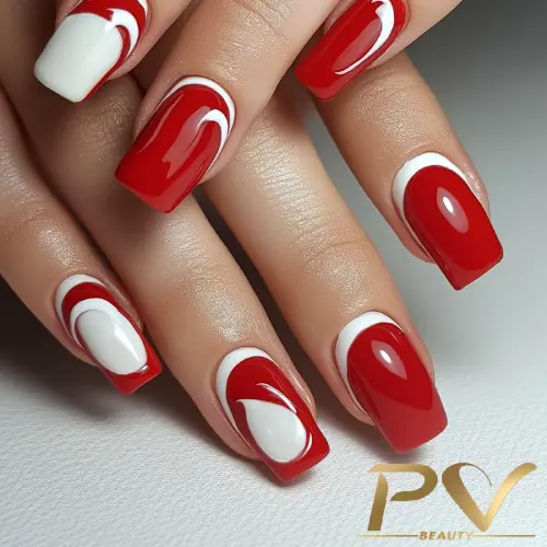 Unhas decoradas com esmalte vermelho e branco, com design de curvas e formas geométricas.