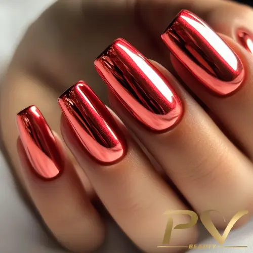 Unhas com esmalte metálico vermelho brilhante, destacando-se sobre um fundo neutro.