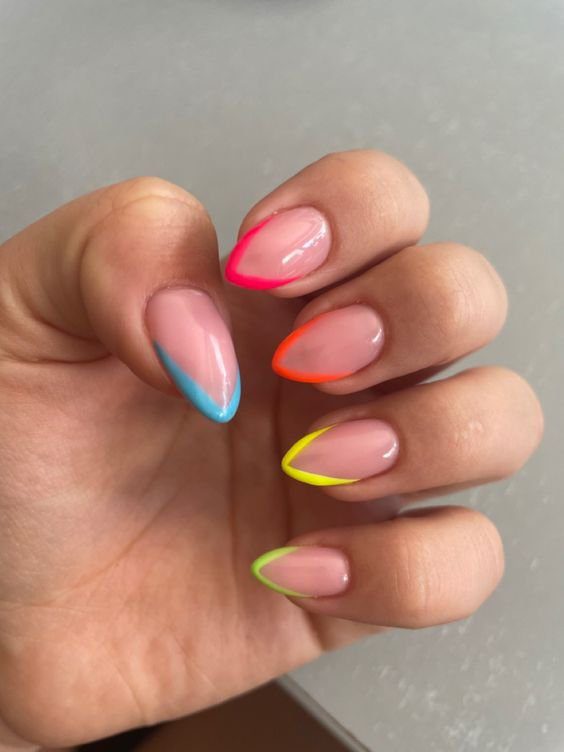 francesinha-colorida-cor-e-marca-desconhecidas-pinterest Mão com unhas pintadas em tons neon variados, cada unha com uma cor diferente na ponta.