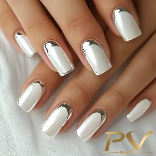 Unhas decoradas com esmaltação branca e detalhes em prata, estilo sofisticado em manicure em São Paulo