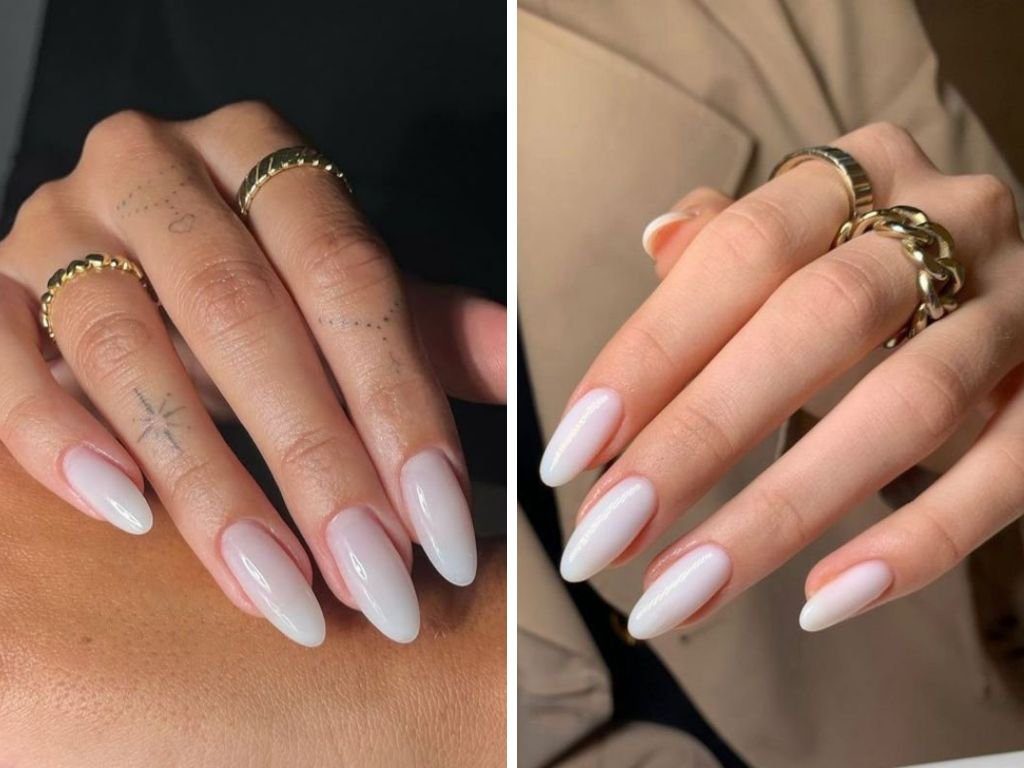 Mãos com unhas longas e brancas, usando anéis dourados.