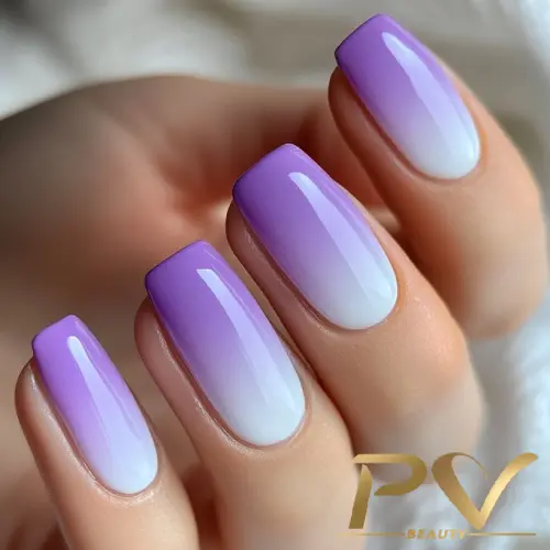 roxo-unhas-babyboomer-decoradas-lindas-pv-beauty-13 Unhas com esmalte degradê em tons de lilás e branco, mostrando um acabamento brilhante e bem cuidado.