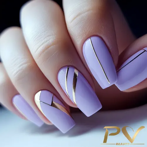 roxo-unhas-decoradas-metais-dourados-pv-beauty-18 Mão com unhas decoradas em tons de lilás e detalhes dourados, mostrando um design geométrico elegante.