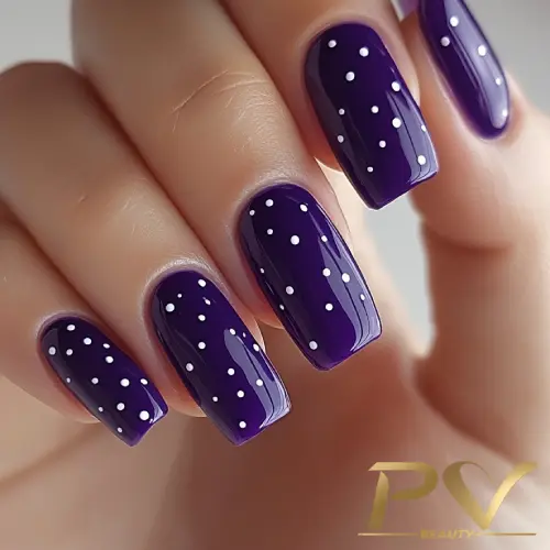 roxo-unhas-decoradas-poa-tradicional-pv-beauty-20 Unhas pintadas de roxo escuro com bolinhas brancas, mostrando uma manicure decorada.