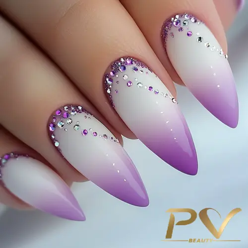 roxo-unhas-degrade-strass-decoradas-pv-beauty-04 Unhas longas com esmalte em degradê roxo e branco, decoradas com pequenas pedras brilhantes.