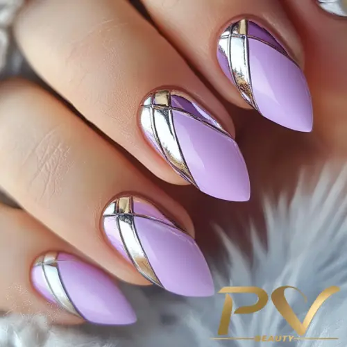 Unhas decoradas em tons de lilás e prata, com detalhes geométricos metálicos.