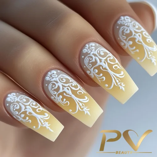 unhas-amarelas-arabescos-brancos-decoradas-pv-beauty-29 Unhas decoradas com esmalte amarelo e desenhos brancos detalhados, em estilo floral, sobre um fundo gradiente.