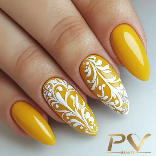 unhas-amarelas-arabescos-decoradas-pv-beauty-05 Unhas decoradas em amarelo com detalhes brancos em espiral, mostrando um design sofisticado e artístico.