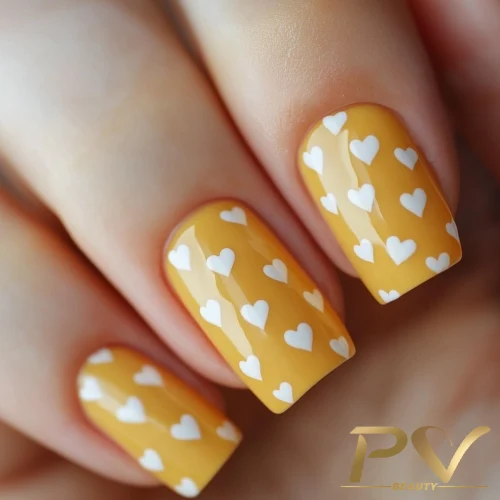 unhas-amarelas-coracao-decoradas-pv-beauty-26 Unhas com esmalte amarelo decoradas com pequenos corações brancos.