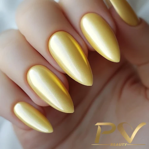 unhas-amarelas-fosco-esmalte-decoradas-pv-beauty-27 Unhas compridas e pontudas com esmalte dourado brilhante em uma mão.