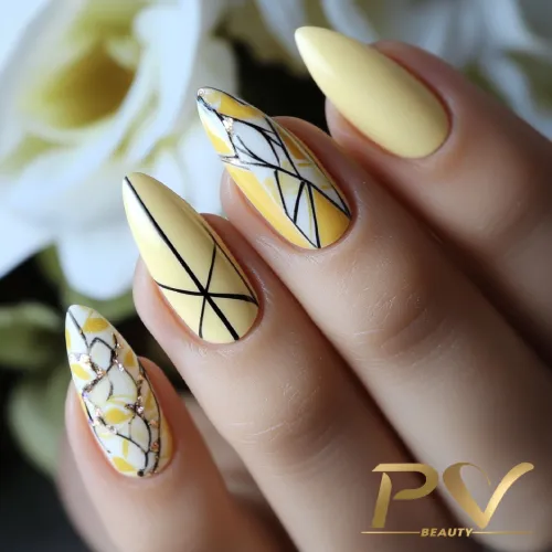unhas-amarelas-geometricas-decoradas-pv-beauty-21 Unhas decoradas com esmalte amarelo e desenhos geométricos em preto e branco.