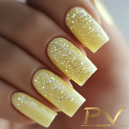 unhas-amarelas-glitter-decoradas-pv-beauty-19 Unhas pintadas de amarelo com glitter prateado, destacando brilho e elegância.
