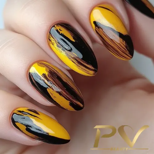 unhas-amarelas-pinceladas-artisticas-decoradas-pv-beauty-15 Unhas decoradas com esmalte amarelo e preto em um design artístico abstrato.