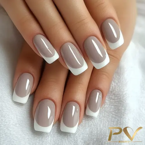 unhas-cinza-francesinha-linda-pv-beauty-08 Unhas bem cuidadas com esmalte nude e pontas brancas, estilo francesinha, sobre tecido branco.