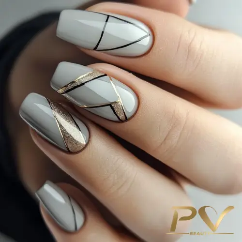 unhas-cinza-lindas-decoradas-pv-beauty-05 Unhas com esmalte cinza e detalhes geométricos em preto e dourado, com acabamento brilhante.