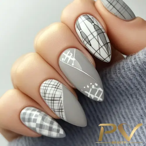 unhas-cinza-xadrez-decoracao-pv-beauty-29 Unhas decoradas com esmalte cinza e padrões geométricos em preto e branco, em um fundo de tecido cinza.