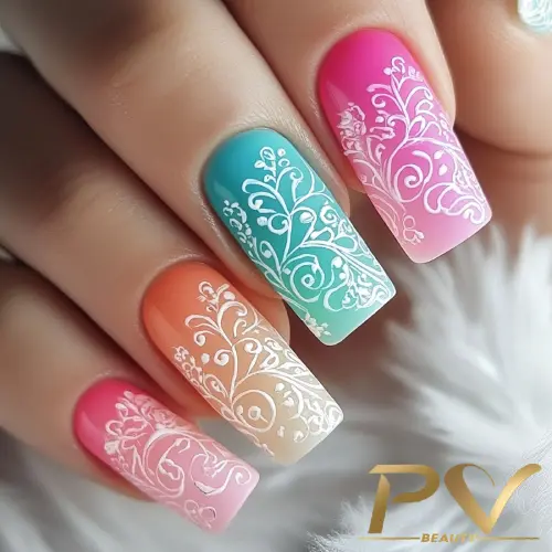 Unhas decoradas com esmalte em degradê colorido e desenhos brancos detalhados sobre um fundo neutro.