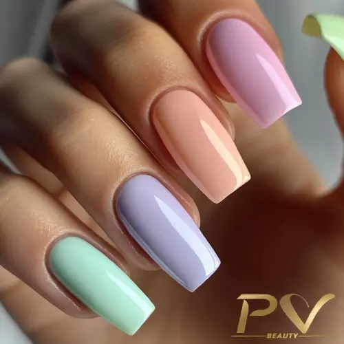 Mão com unhas compridas e quadradas, pintadas em tons pastel: verde, lilás, pêssego e rosa, sobre fundo claro.