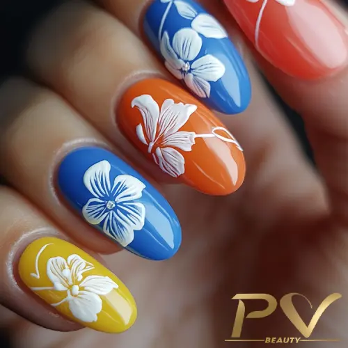 Unhas coloridas decoradas com flores brancas sobre fundo azul, laranja e amarelo.