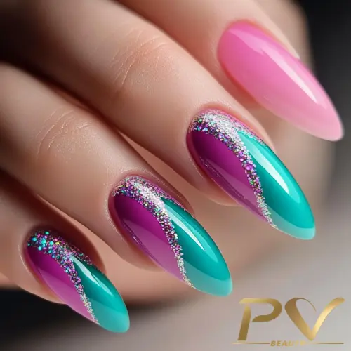 Unhas decoradas com esmalte rosa, roxo e verde, adornadas com detalhes prateados brilhantes.
