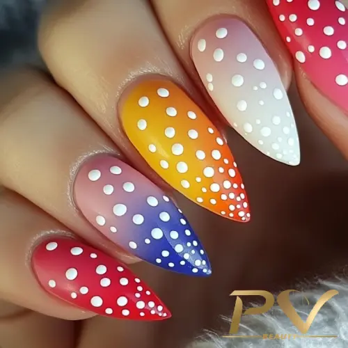 Unhas com esmalte em degradê colorido e bolinhas brancas, em tons de rosa, azul, laranja e vermelho.