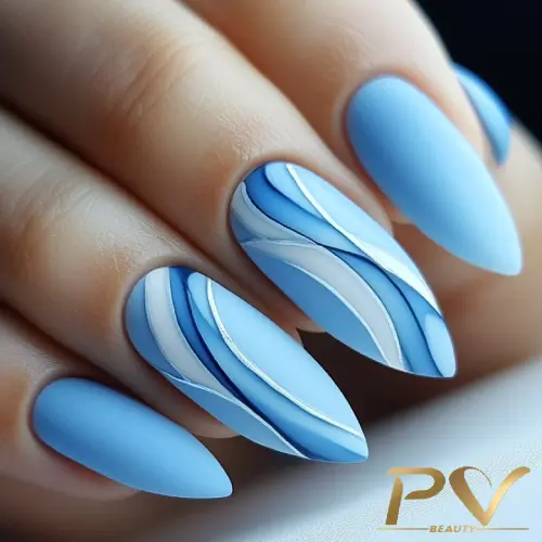 unhas-decorada-azul-claro-curvas-assimetricas-pv-beauty-11 Unhas com esmalte azul claro e decoração de linhas onduladas em tons de azul e branco, com acabamento fosco.