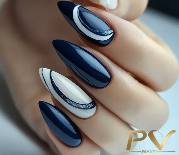 unhas-decorada-azul-curvas-detalhes-branco-pv-beauty-04 Unhas com esmalte azul e branco em design geométrico, mostrando detalhes brilhantes e linhas curvas.