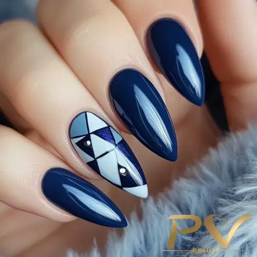 unhas-decorada-azul-formas-geometricas-pv-beauty-25 Unhas esmaltadas de azul escuro com design geométrico em preto, branco e azul em uma das unhas.