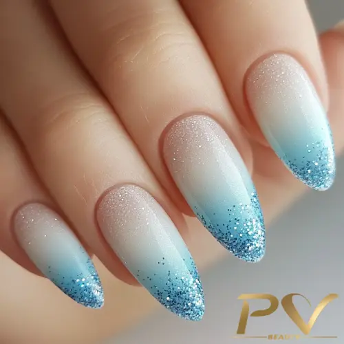 unhas-decorada-azul-glitter-ombre-pv-beauty-22 Unhas com esmalte degradê azul e glitter nas pontas, formato oval e acabamento brilhante.