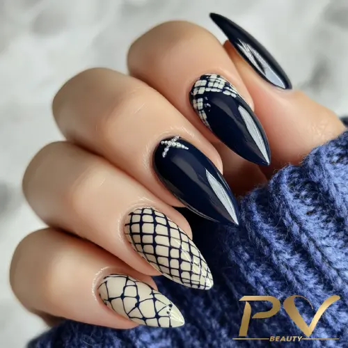 unhas-decorada-azul-stiletto-quadriculadas-pv-beauty-19 Unhas em formato stiletto com esmalte preto e nude, decoradas com padrões geométricos e detalhes prateados.