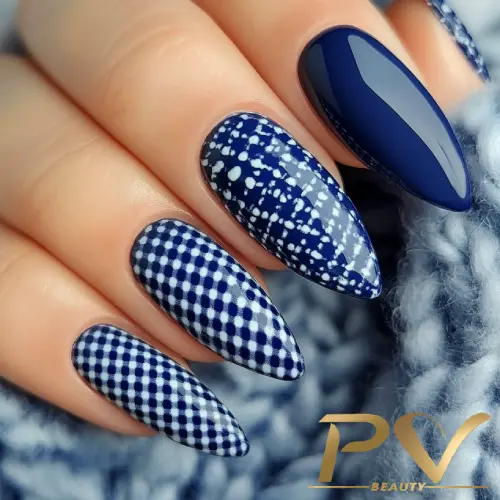 unhas-decorada-azul-xadrez-vichy-pv-beauty-08 Unhas decoradas com esmalte azul e padrões geométricos, incluindo xadrez e bolinhas, em fundo de lã azul.