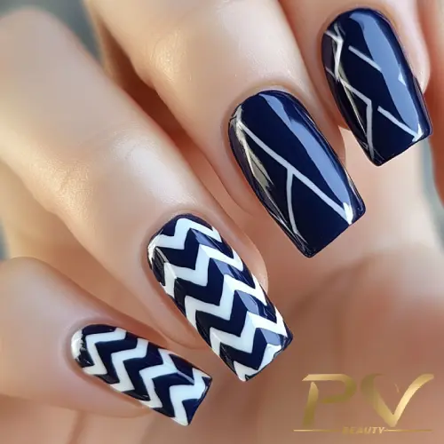 unhas-decorada-azul-zig-zag-pv-beauty-31 Unhas decoradas com esmalte azul escuro e branco, apresentando padrões geométricos e ziguezagues.