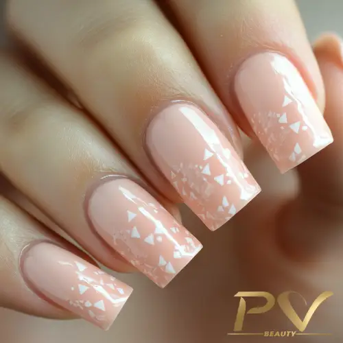 Mão com unhas longas esmaltadas em tom rosa claro, decoradas com detalhes geométricos brancos.
