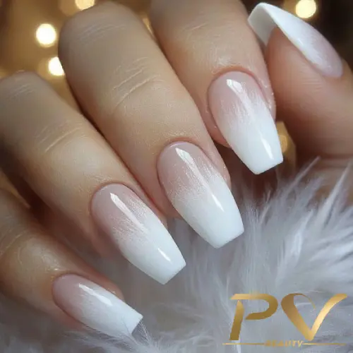 unhas-decoradas-branco-ombre-perfeito-pv-beauty-17 Mãos com unhas compridas em estilo degradê branco, segurando suavemente uma textura felpuda.