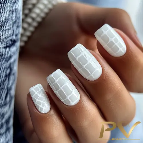 unhas-decoradas-branco-quadriculado-maravilhoso-pv-beauty-12 Mão com esmalte branco e desenho geométrico em relevo nas unhas curtas e quadradas.